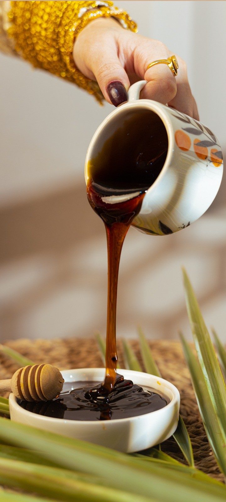 Date syrup being poured from a ceramic jug